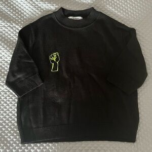 Black crop top with the fist hand logo